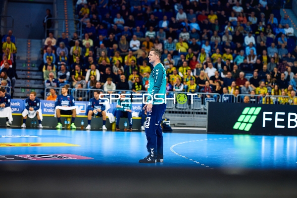 Ein Spieler von SG Flensburg beobachtet das Spielgeschehen vom Spielfeldrand.