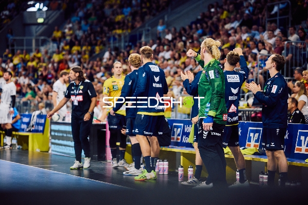 Spieler auf der Bank von Rhein Neckar Löwen und THW Kiel während des Spiels.