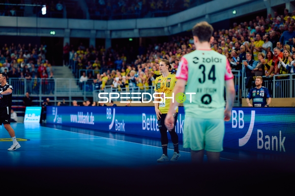 Spielunterbrechung am Spielfeldrand mit zwei Spielern im Vordergrund.