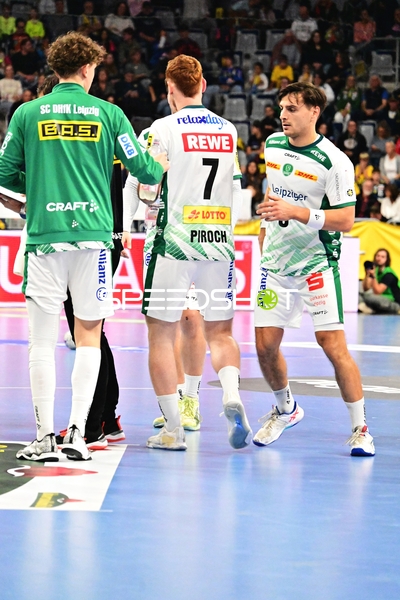 Drei SC DHfK Leipzig Spieler im Gespräch auf dem Spielfeld