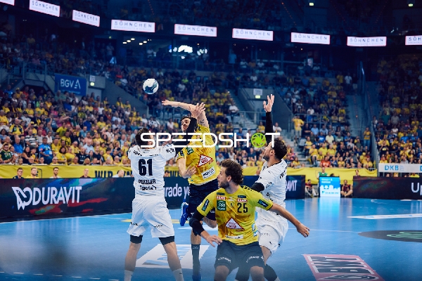 Spieler Nummer 25 von Rhein Neckar Löwen springt, um den Ball zu fangen oder zu blocken.