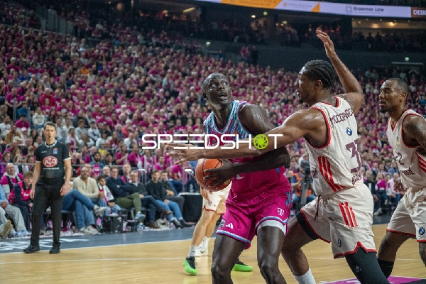 Isiaha Mike (22; FC Bayern Basketball) mit Ball gegen Kur Jongkuch (15; Telekom Baskets Bonn)