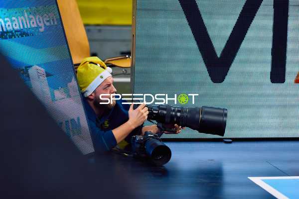 Ein Fotograf liegt am Spielfeldrand und macht Fotos.