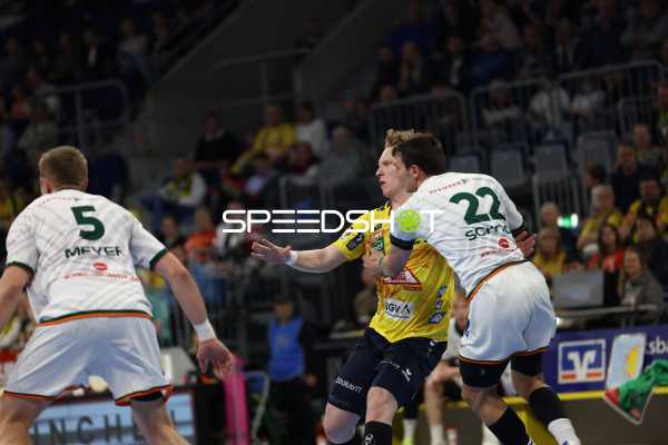 Ein Spieler der Rhein Neckar Löwen versucht, an zwei Verteidigern von HSG Wetzlar vorbeizukommen.