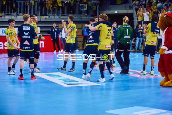 Spieler von Rhein Neckar Löwen feiern auf dem Spielfeld.
