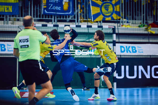 Ein Spieler von ThSV Eisenach greift mit dem Ball an und wird von zwei Spielern der Rhein Neckar Löwen verteidigt.