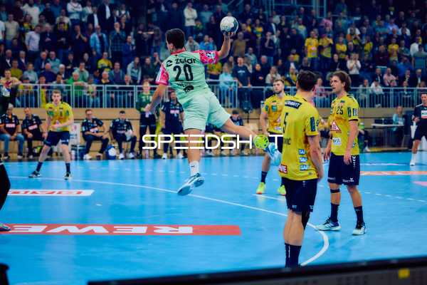 Ein Spieler von Füchse Berlin springt zum Wurf, während Spieler von Rhein Neckar Löwen verteidigen.