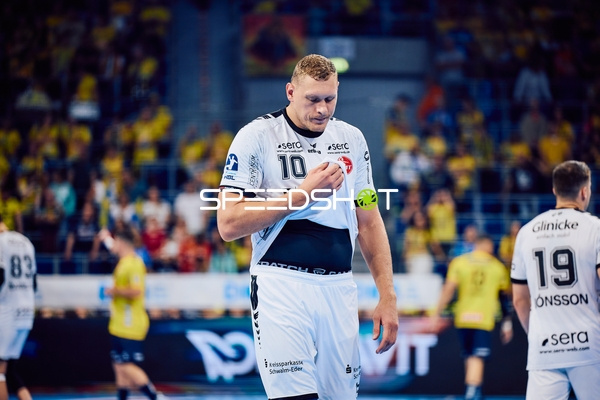 Ein Spieler von MT Melsungen mit der Nummer 10 schaut nach unten und hält sein Trikot.