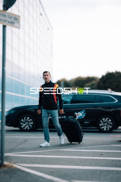 Person mit Koffer vor Arena