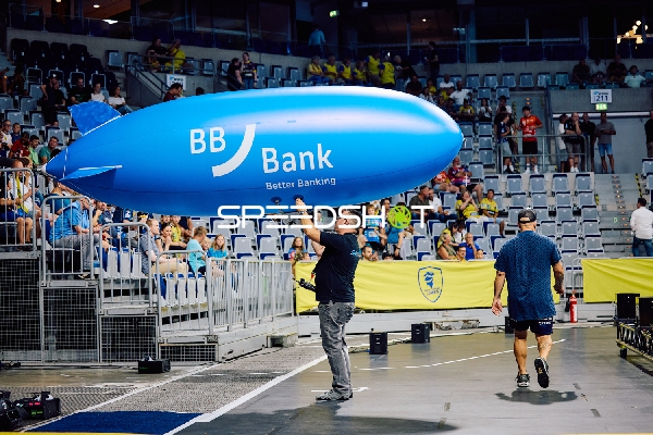 Ein Werbeluftschiff wird in der Halle getragen.