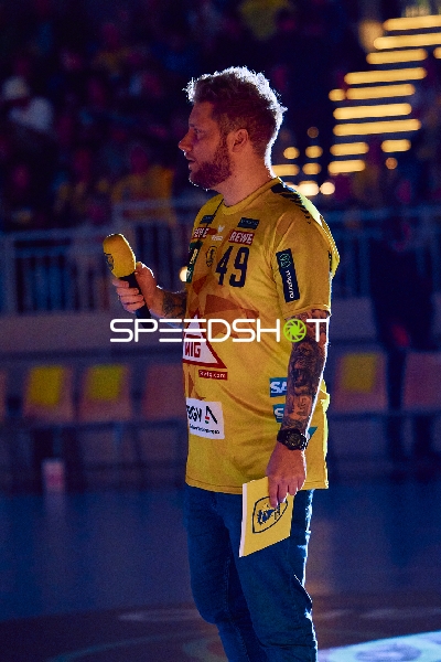 Ein Moderator mit einem Mikrofon auf dem Spielfeld