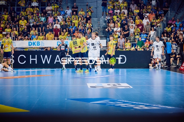 Spieler von Rhein Neckar Löwen und THW Kiel sind auf dem Spielfeld in Aktion.