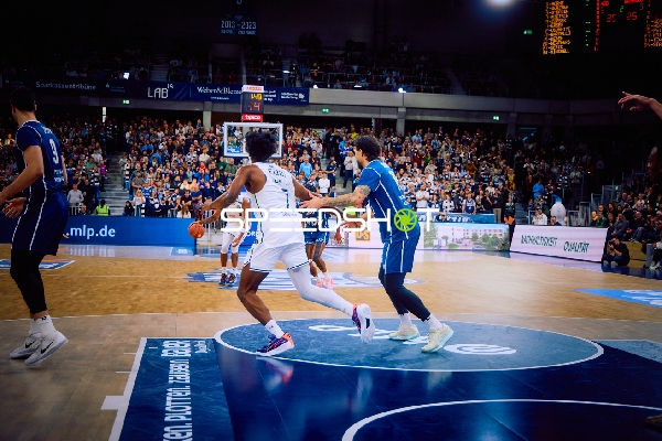 Ein Spieler dribbelt den Ball Richtung Korb.