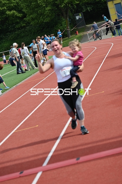 Läuferin mit Kind auf der Bahn