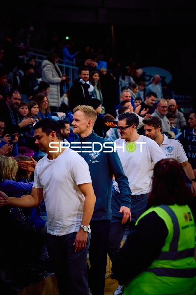 Spieler betreten das Spielfeld und begrüßen die Fans.