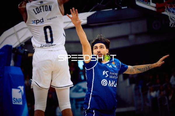 Ein Spieler von Brose Bamberg führt einen Sprungwurf aus, während ein Spieler der MLP Academics Heidelberg verteidigt.