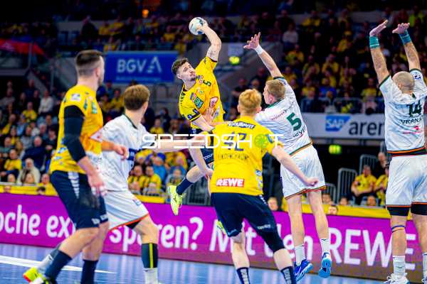 Ein Spieler der Rhein-Neckar Löwen springt für einen Wurf gegen die Abwehr von HSG Wetzlar.