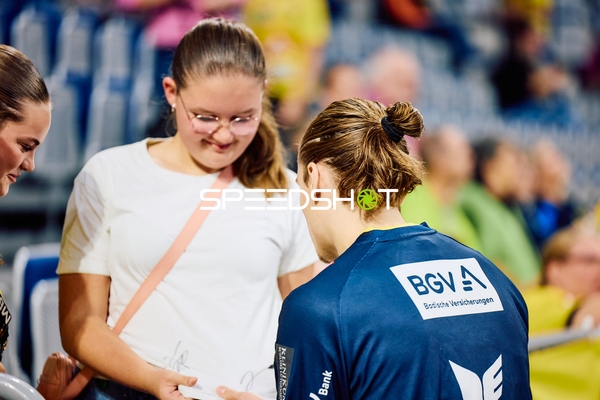 Ein Spieler unterschreibt Autogramme für Fans.