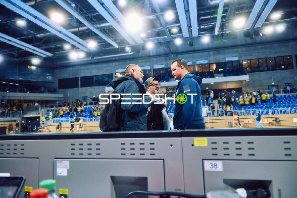 Personen diskutieren neben dem Spielfeld