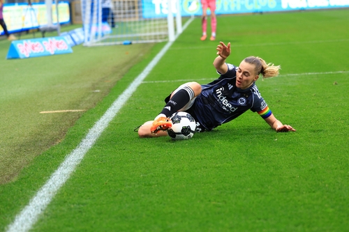 Spielerin rutscht mit Ball