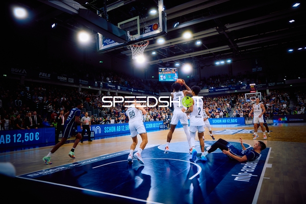 Ein Spieler von MLP Academics Heidelberg geht zum Korb während ein Spieler am Boden liegt.