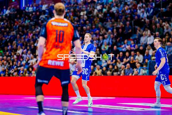 Ein Spieler von Rhein Neckar Löwen in Orange steht einem Spieler von VfL Gummersbach gegenüber.
