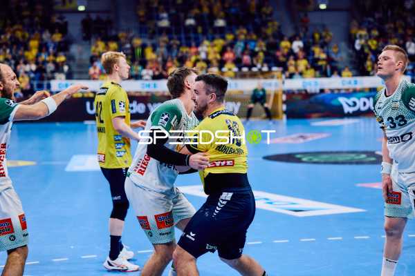 Ein Spieler der Rhein-Neckar Löwen umarmt oder blockiert einen Spieler von Frisch Auf Göppingen.