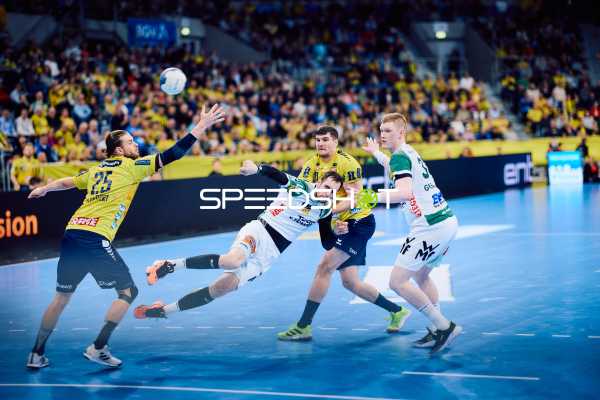 Ein Spieler von Rhein Neckar Löwen versucht, den Ball zu erreichen, während ein Spieler von Frisch Auf Göppingen in der Verteidigung angerempelt wird.