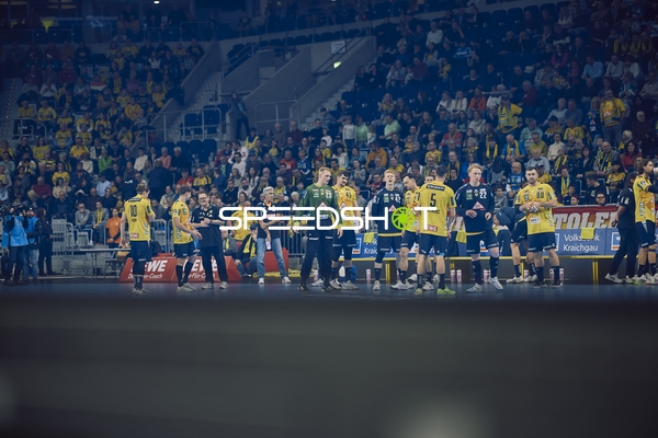 Die Spieler der Rhein Neckar Löwen und SC Magdeburg begrüßen sich auf dem Spielfeld vor dem Spiel.