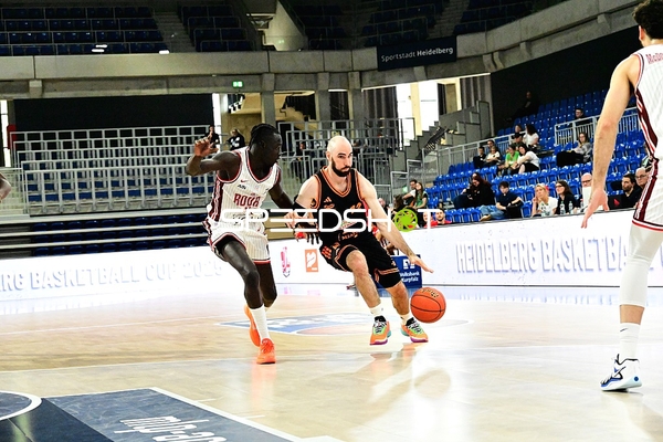 Tommy Kuhse (12; Rasta Vechta) dribbelt, Tre Mitchell (3; JL Bourg Basket) verteidigt