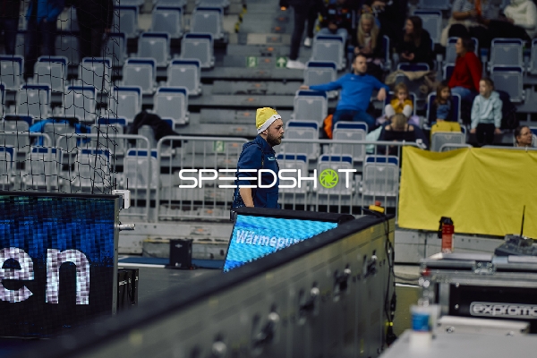 Ein Trainer oder Betreuer steht am Spielfeldrand.