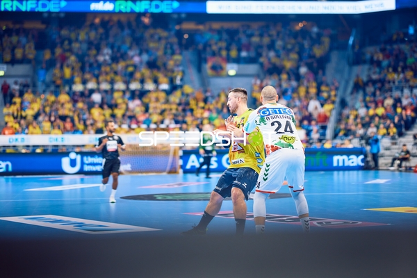 Ein Spieler von SC Magdeburg blockt einen Spieler der Rhein Neckar Löwen.