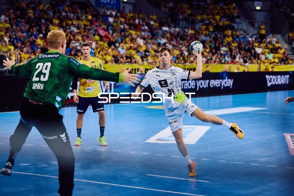 Ein Spieler von THW Kiel, Bence Imre, ist im Angriff, während der Torhüter von Rhein Neckar Löwen bereit ist zu parieren.