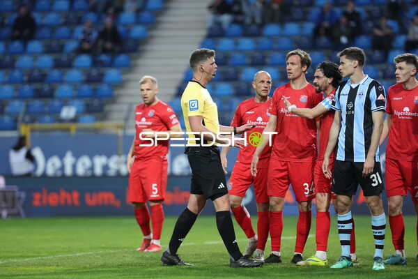 Spieler diskutieren mit Schiedsrichter