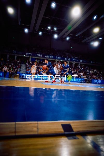 Ein Spieler treibt den Ball während eines Basketballspiels voran.