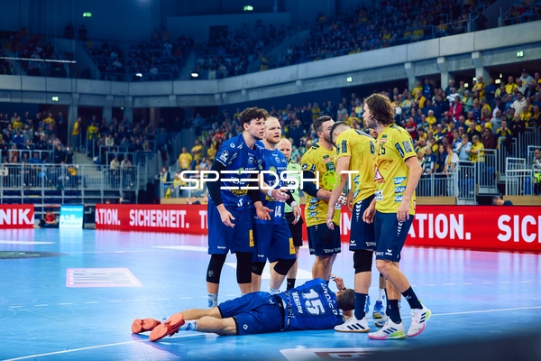 Ein Spieler liegt verletzt auf dem Boden, während andere Spieler um ihn herum stehen.