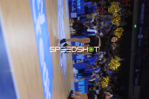 Cheerleader zeigen Tanz mit goldenen Pompons