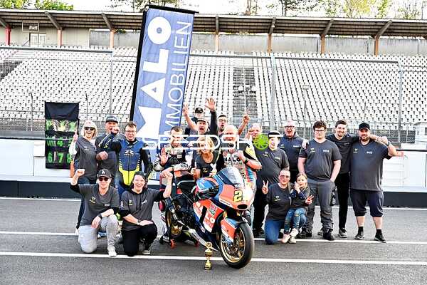 Gruppe mit Motorrad und Pokal