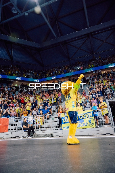 Maskottchen auf dem Spielfeld grüßt die Zuschauer.