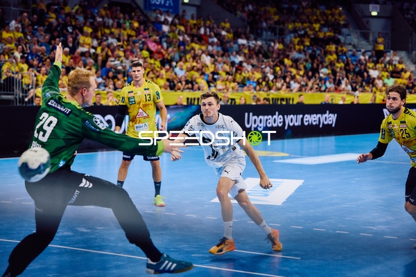 Ein Spieler von THW Kiel versucht, auf das Tor zu werfen, während der Torhüter der Rhein Neckar Löwen sich vorbereitet, den Ball zu stoppen.