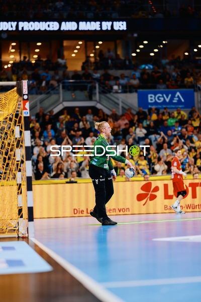 Der Torwart der Rhein-Neckar Löwen steht bereit, während ein Spieler von TSV Hannover-Burgdorf im Hintergrund zu sehen ist.