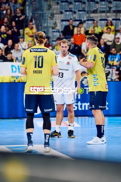 Spieler von Rhein Neckar Löwen und HSV Hamburg diskutieren auf dem Spielfeld.