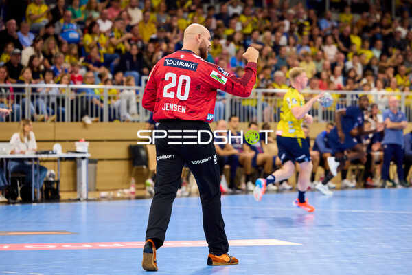 Handball I Herren I Saison 2025-2026 I Testspiel I Rhein-Neckar Löwen – Paris Saint-Germain I 03.08.2025 Torwart Mike Jensen (20; Rhein Neckar Löwen) im roten Matchtrikot in Position; im Hintergrund Spieler der Rhein Neckar Löwen und Paris Saint-Germain in der Halle. - Mike Jensen