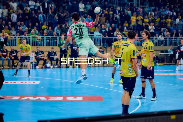 Ein Spieler von Füchse Berlin springt zum Wurf, während Spieler von Rhein Neckar Löwen verteidigen.