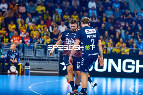 Zwei Spieler von SG Flensburg Handewitt stehen auf dem Spielfeld.