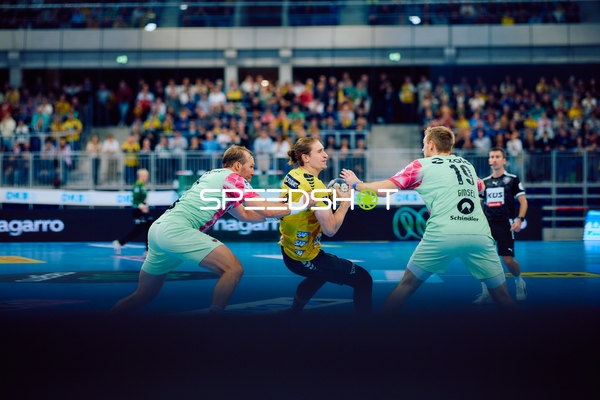 Ein Spieler von Rhein Neckar Löwen wird von zwei Spielern von Füchse Berlin verteidigt.