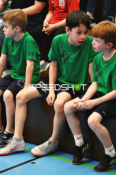 Kinder in grünen Shirts auf Hallenbank