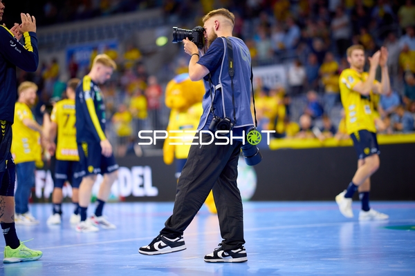 Spieler und Fotograf auf dem Spielfeld