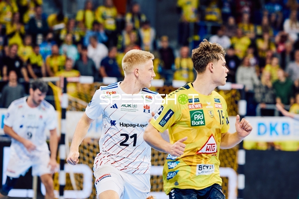 Ein Spieler von Rhein Neckar Löwen und ein Spieler von HSV Hamburg sind in Bewegung, möglicherweise in einer Spielsituation.