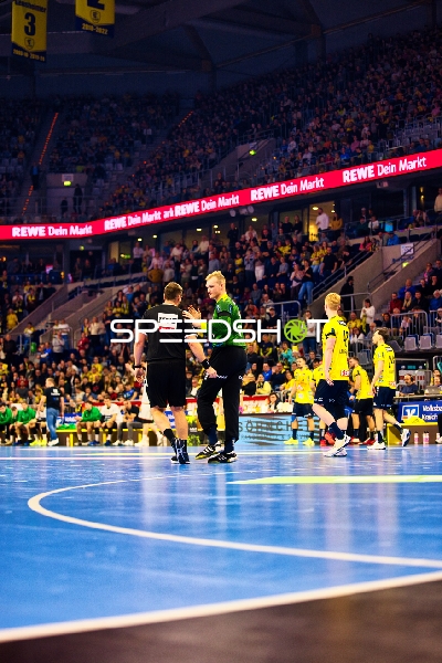 Ein Schiedsrichter unterhält sich mit einem Spieler auf dem Spielfeld.